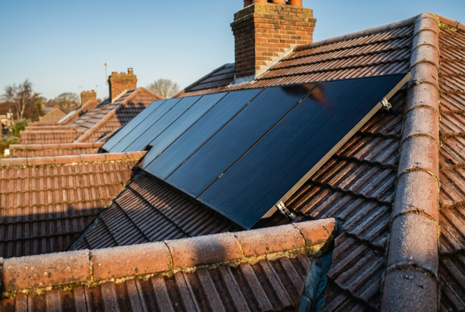Solar PV panels generating on a frosty UK roof under a bright winter sun
